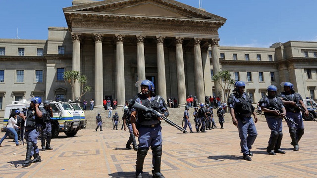  South African police forces members patrol the Wits University campus during ongoing clashes with #