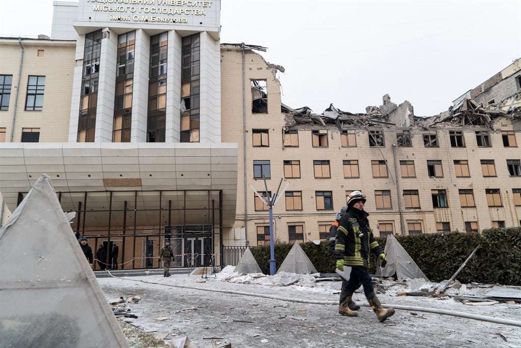 Rescuers walk among debris in front of the damaged O. M. Beketov National University of Urban Economy in Kharkiv, Ukraine, on 5 February 2023. On the morning of 5 February, a Russian missile hit the university building and an apartment building. Five people were injured. (Photo by Viacheslav Mavrychev/Suspilne Ukraine/JSC UA:PBC/Global Images Ukraine via Getty Images)