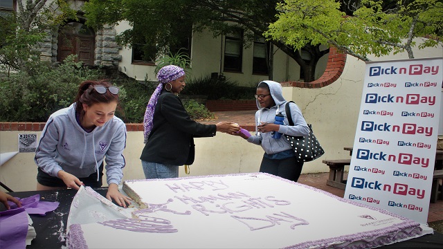 Project Manager and Treasurer General handing out cake at The Kaif for Human Rights Day