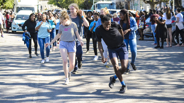 Denzel Nyathi (in black) leads a group of dancers from the Rhodes University drama department