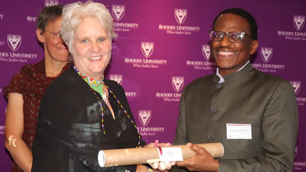 Rhodes University Vice-Chancellor Professor Sizwe Mabizela hands over the JMS 50th award to the School of Journalism and Media Studies alumna and SABC TV's senior manager, Deirdre Uren. 