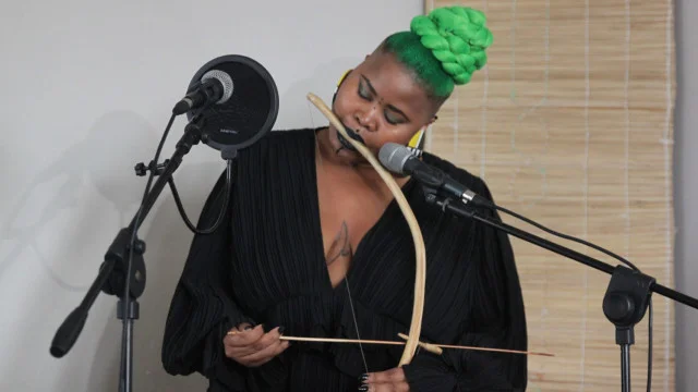 Thandeka Mfinyongo, a PhD student in Ethnomusicology, plays uhadi and umrhubhe.