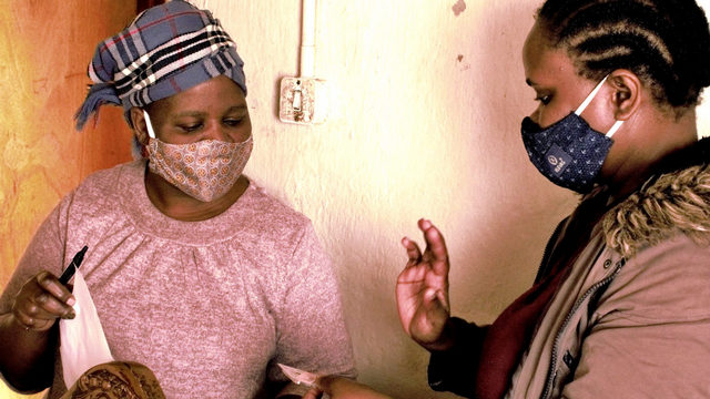 An SD card is handed over to a Vulindlela parent. (Photo: Dylan Coetzee).