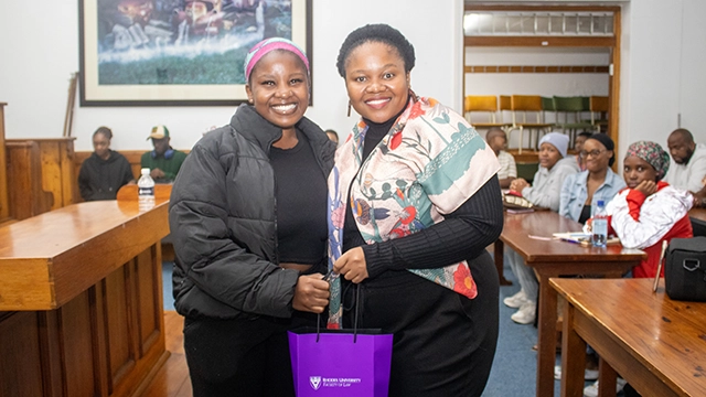 Dr Nomalanga Mashinini (right) accepts a gift from a student at her lecture