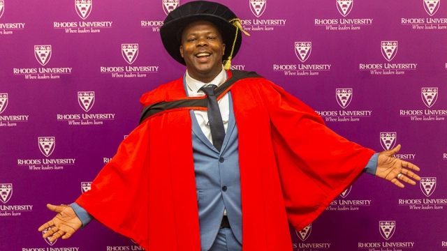 Dr Sam Motitsoe proudly wears the red gown given to him by Emeritus Professor Cliff Moran. 
[PIC CREDIT: Vusumzi Tshekema]
