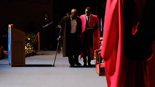 Dr Stones Chindipha (right) helps visually-impaired Mbongeni Shabangu to cross the stage at his graduation