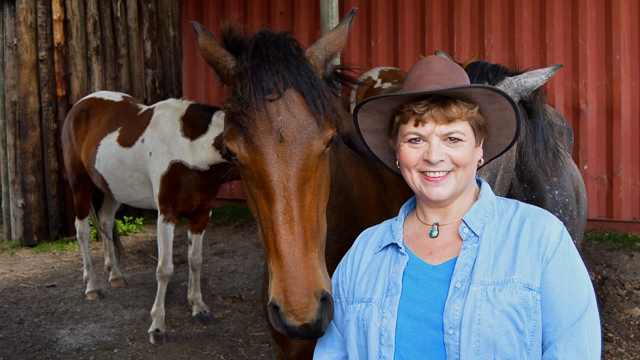 Manager of Academic Administration, Suzette Flanagan, stands with two of her horses