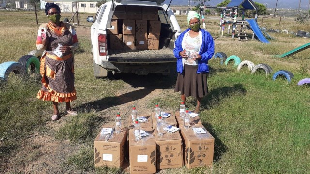 ECD practitioners Nonyameko Mbula (Mandela Educare Centre) and Nomakhaya Nothemba Hoyi (Masithembe Educare Centre) receive sanitiser as part of Ubunye's Covid-19 Response Programme.
