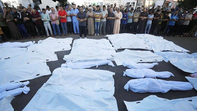 Relatives of Palestinians who died in the Israeli airstrikes perform funeral prayer around the bodies taken from the morgue of Al-Aqsa Martyrs Hospital in Deir Al-Balah, Gaza on November 06, 2023. (Photo by Ashraf Amra/Anadolu via Getty Images)